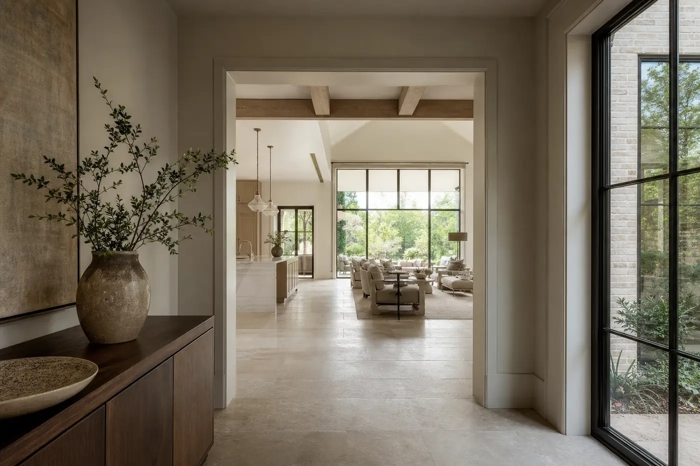 View from an intimate custom-home gallery through a deep opening into a taller kitchen and great room