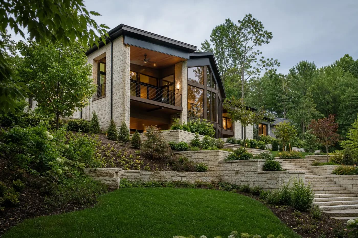 Luxury custom home stepped into a wooded slope with restrained stone terraces