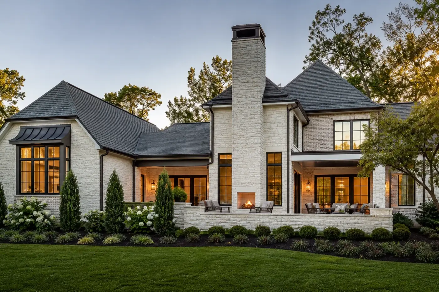 New Charlotte luxury custom home with an integrated limestone chimney and garden-facing fireplace