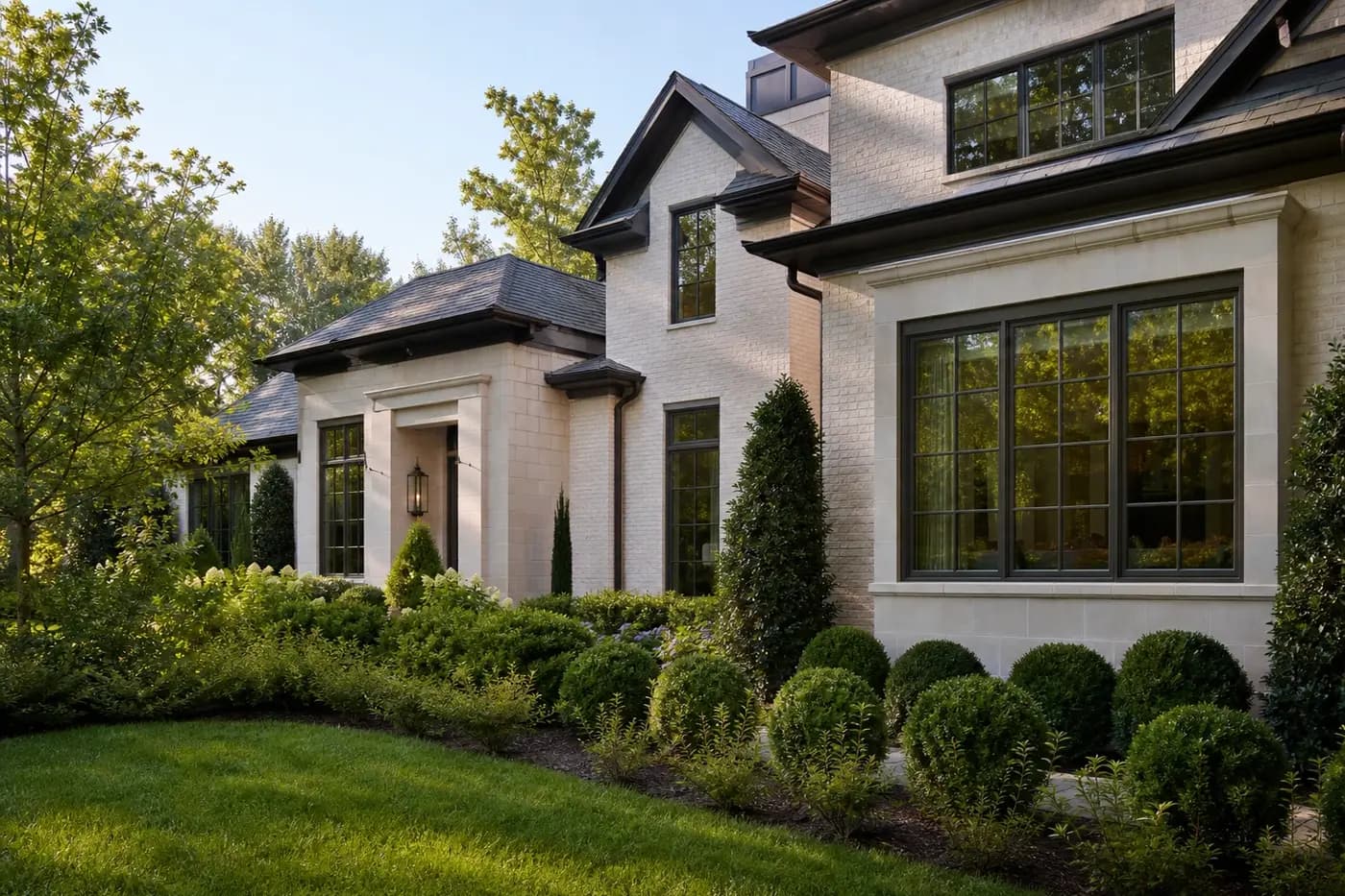 Refined Charlotte custom home with bronze-framed windows, deep roof overhangs, and soft morning light