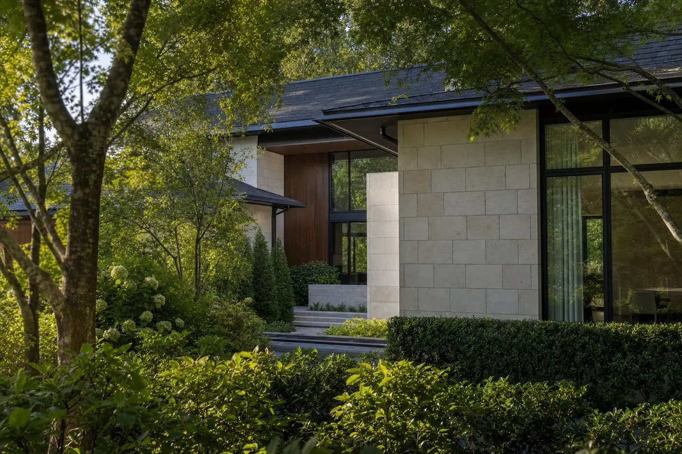 Luxury Charlotte custom home screened by layered trees and garden walls around a private entry court